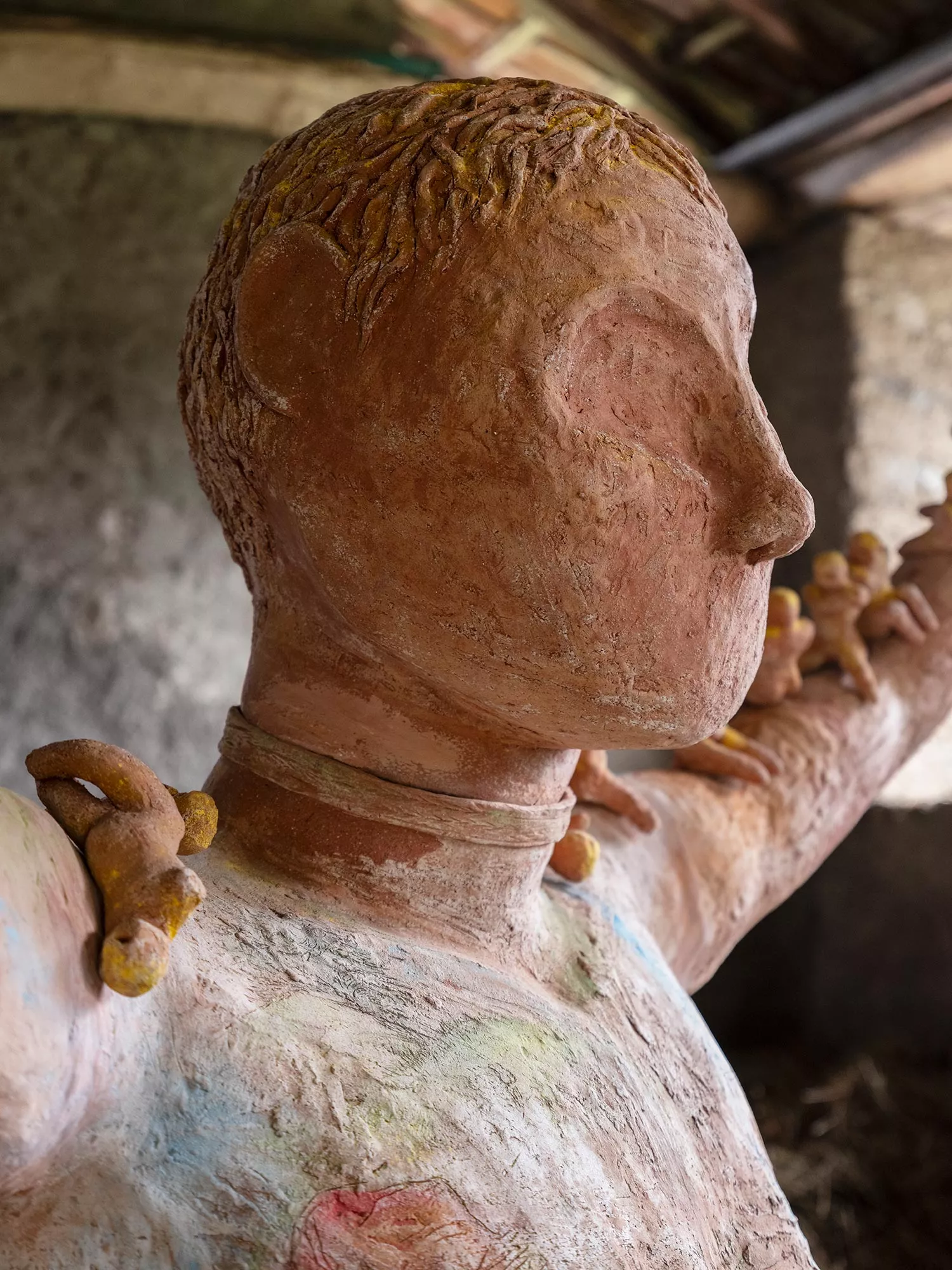 Gaia Fugazza - Gaia Fugazza, Mother of Millions, 2025, close-up of the large human sculpture’s head, with small human figures visible along the arms.